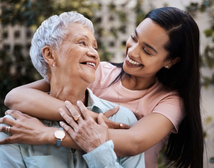 Happy, hug and loving of a mother and woman in a garden on mothers day with care and gratitude together. Smile, family and an adult daughter hugging a senior mom in a backyard or park for happiness.
